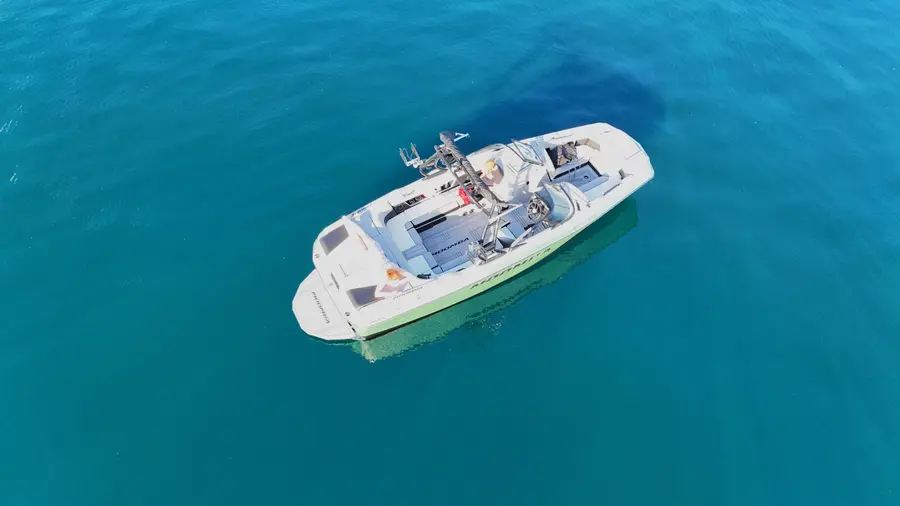 Aerial view of a wake boat floating in clear blue water