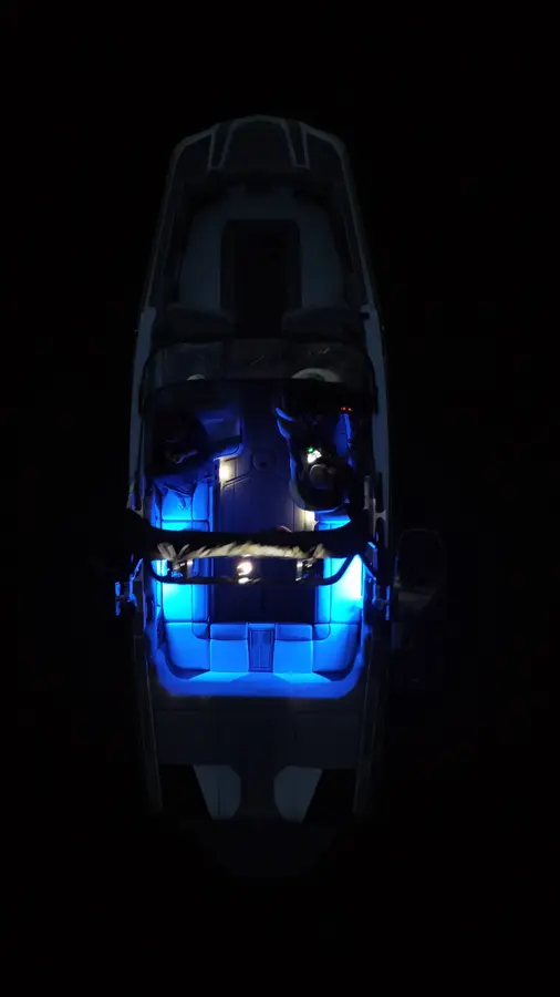 Top-down night view of a boat illuminated in blue