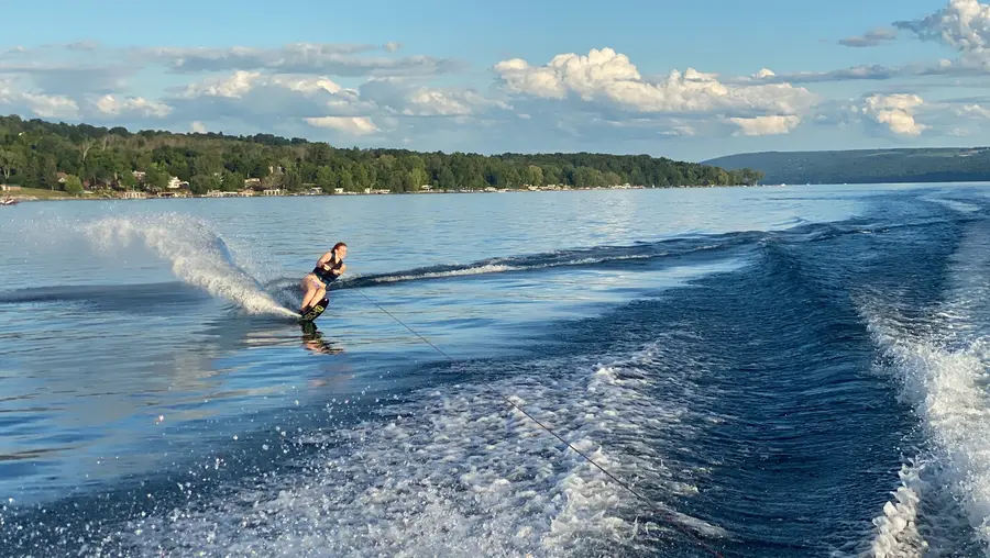 A water skier carving hard across calm water